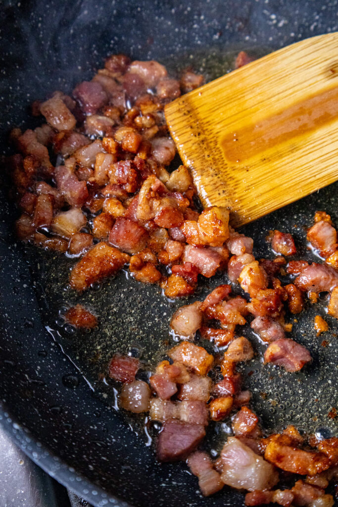 crispy pancetta cooking in a frying pan