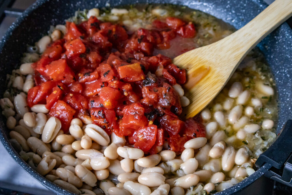 fire roasted tomatoes sitting on top of a bed of white cannellini beans