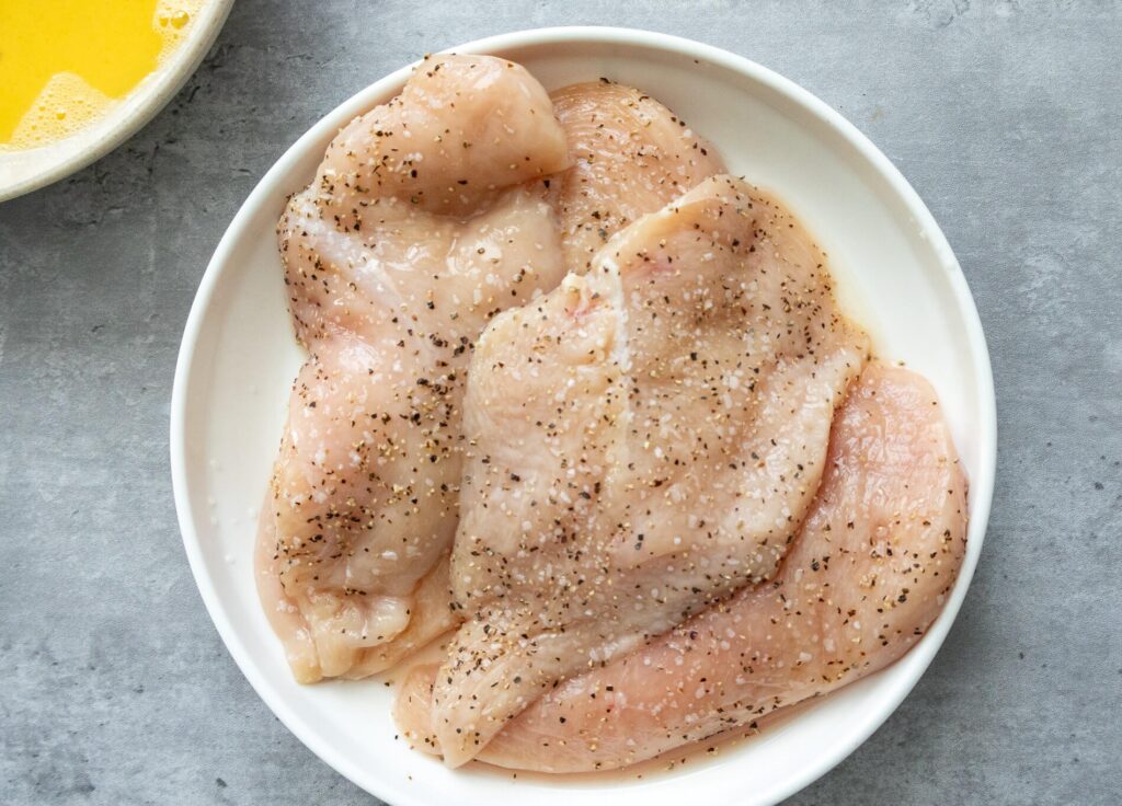 chicken breasts with salt and pepper on them 