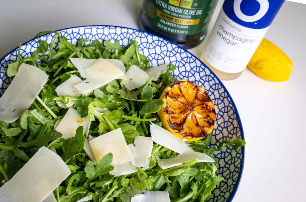 a close up of parmesan and lemon arugula salad